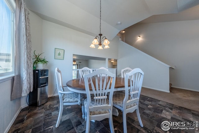 dining room with a healthy amount of sunlight, stone finish floor, and vaulted ceiling
