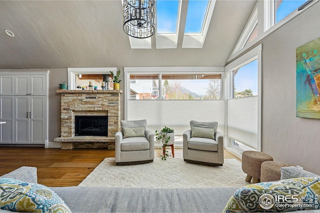 interior space with a fireplace, wood finished floors, vaulted ceiling, and a wealth of natural light