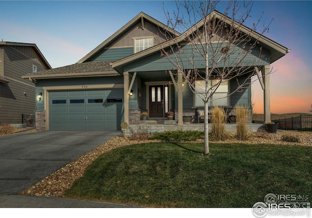 craftsman inspired home with a garage, aphalt driveway, a lawn, fence, and a porch