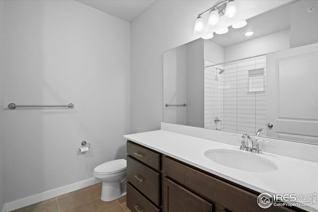 full bath featuring tile patterned flooring, a shower, vanity, baseboards, and toilet