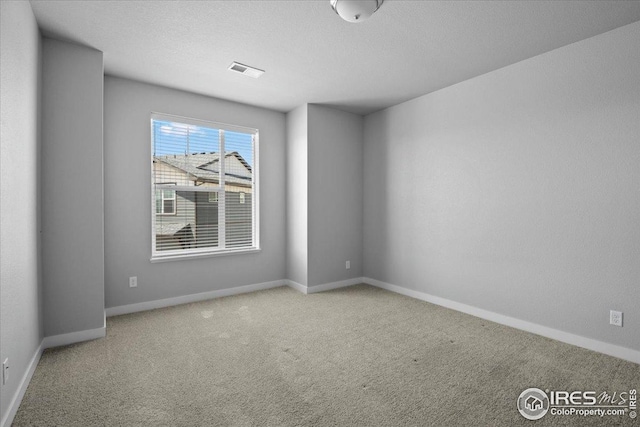carpeted empty room with baseboards and visible vents