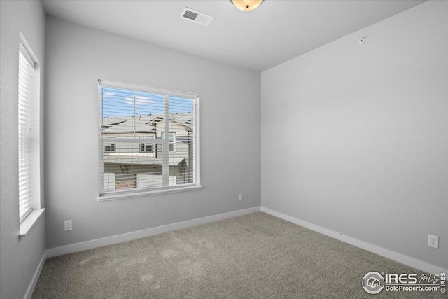 spare room featuring visible vents, carpet flooring, and baseboards
