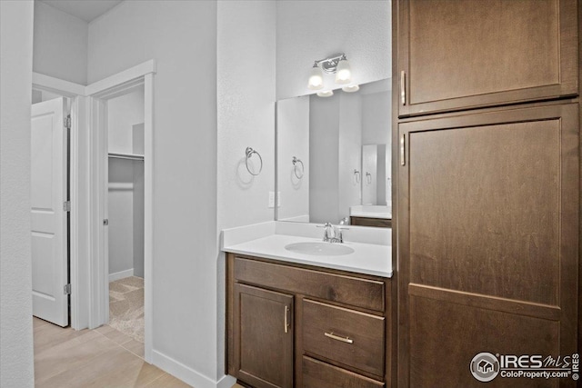 bathroom with vanity and a walk in closet