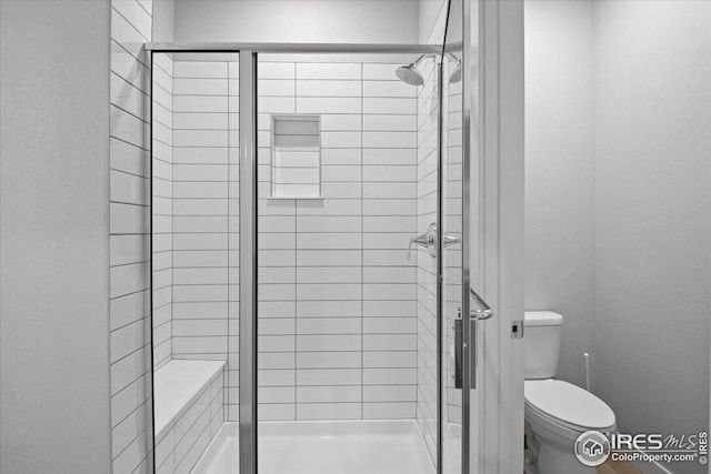 full bathroom featuring a textured wall, a stall shower, and toilet
