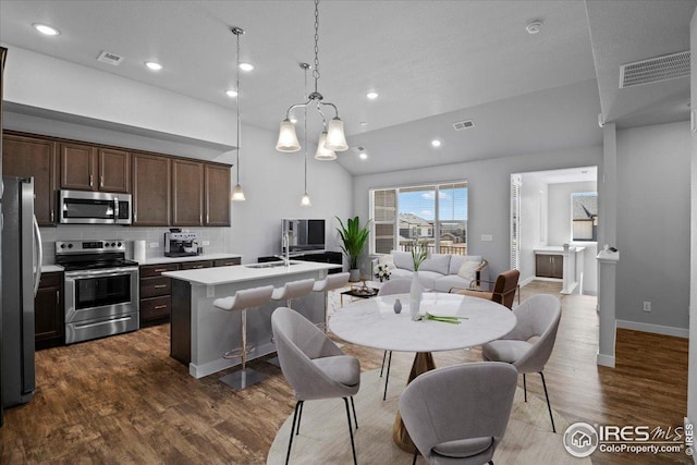 kitchen with light countertops, open floor plan, appliances with stainless steel finishes, and visible vents