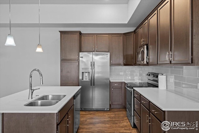 kitchen featuring decorative backsplash, dark wood-style flooring, light countertops, a sink, and stainless steel appliances