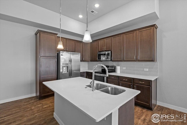 kitchen with baseboards, a sink, appliances with stainless steel finishes, and tasteful backsplash