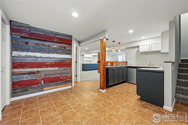 kitchen featuring stainless steel dishwasher, recessed lighting, a sink, and light countertops
