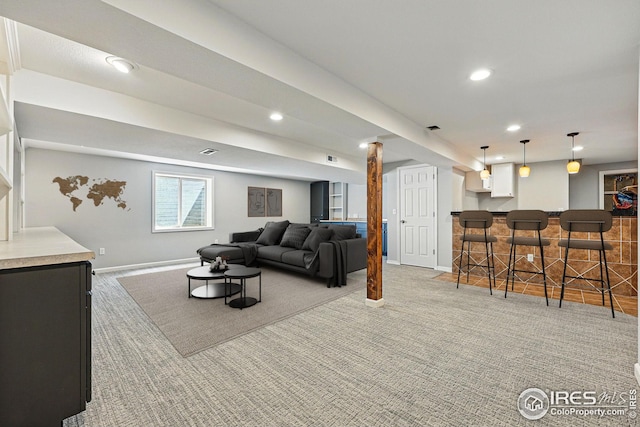 living room featuring recessed lighting, baseboards, bar area, and light carpet