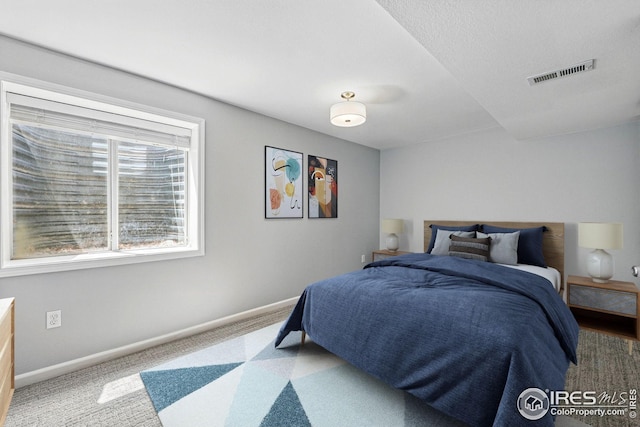 carpeted bedroom featuring baseboards and visible vents