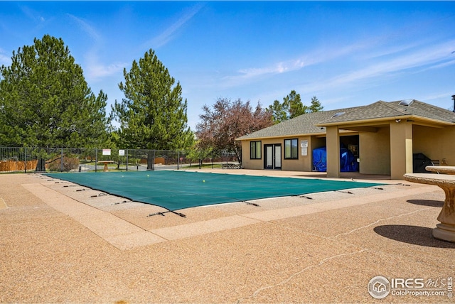 pool featuring a patio, fence, and french doors