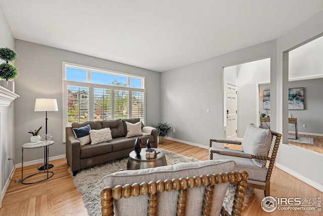 living area with baseboards and wood finished floors