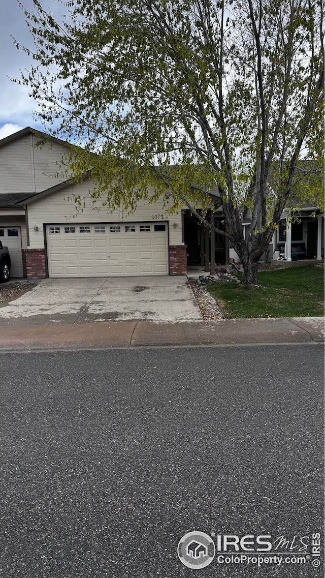 view of front of property featuring concrete driveway, brick siding, and an attached garage