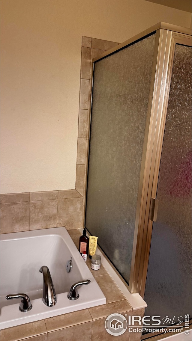 bathroom featuring a shower stall and a garden tub