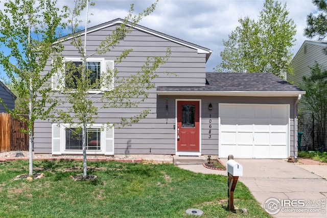 split level home featuring fence, a shingled roof, an attached garage, a front lawn, and concrete driveway