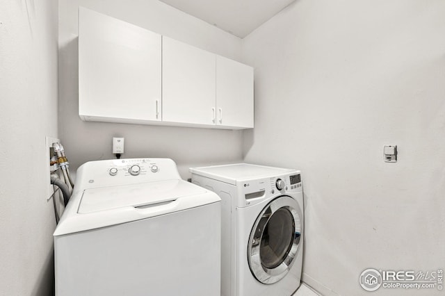 washroom with washer and clothes dryer and cabinet space