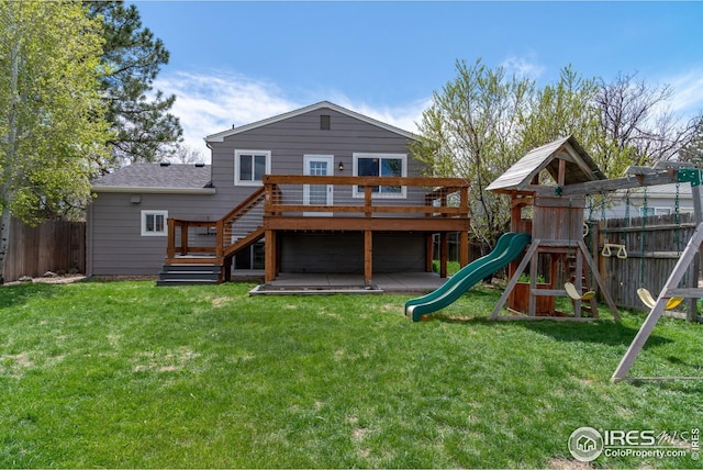 back of property featuring fence, a yard, a playground, and a deck