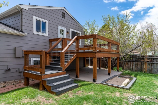 rear view of house featuring a lawn, a deck, stairway, fence, and a patio