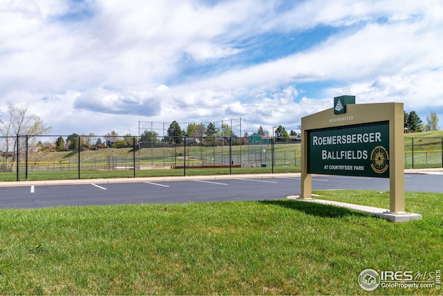 view of sport court featuring fence and a yard
