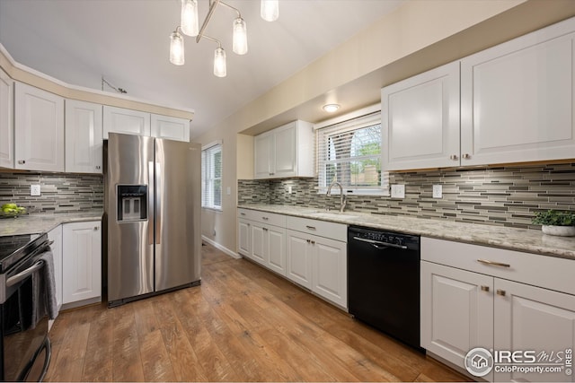 kitchen featuring light wood-style floors, decorative backsplash, white cabinets, and black appliances