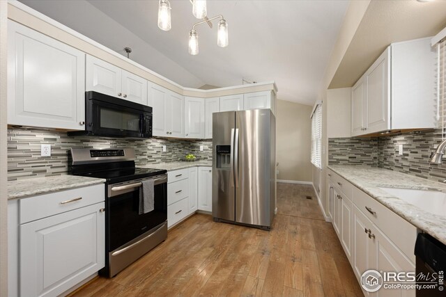 kitchen with decorative backsplash, a sink, white cabinets, black appliances, and lofted ceiling