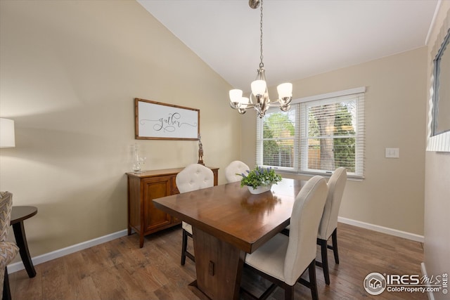 dining area featuring baseboards, lofted ceiling, wood finished floors, and a notable chandelier