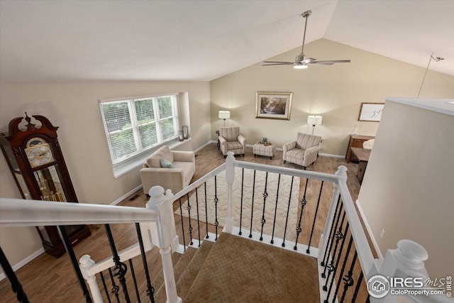 stairway with baseboards, ceiling fan, and vaulted ceiling