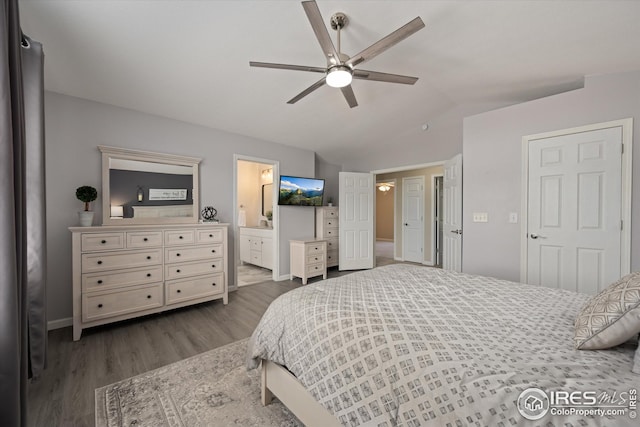 bedroom featuring dark wood-style flooring, baseboards, connected bathroom, a ceiling fan, and vaulted ceiling