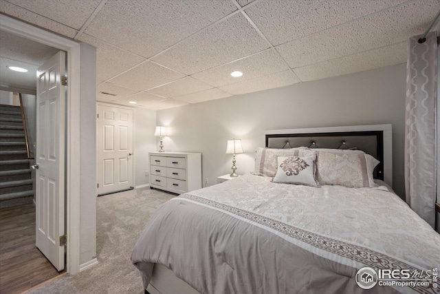 carpeted bedroom with recessed lighting, baseboards, and a drop ceiling