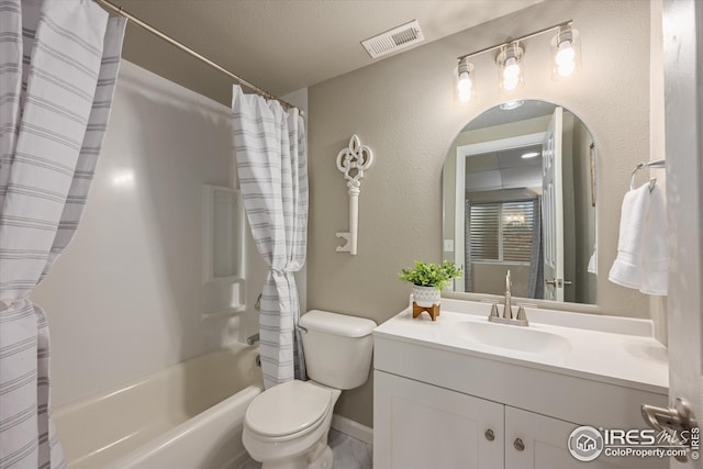 bathroom featuring visible vents, vanity, toilet, baseboards, and shower / tub combo