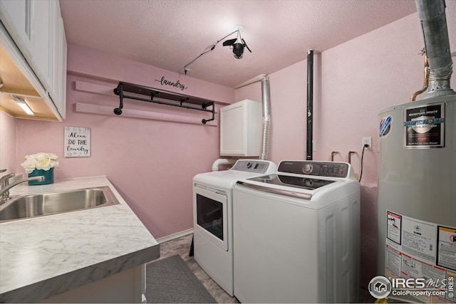 clothes washing area with washer and clothes dryer, a textured ceiling, a sink, cabinet space, and water heater