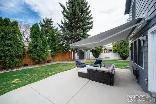 view of patio / terrace with a storage shed, an outbuilding, a fenced backyard, and an outdoor hangout area