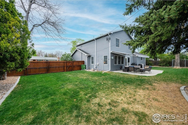 back of house featuring a fenced backyard, a lawn, an outdoor living space, and a patio area