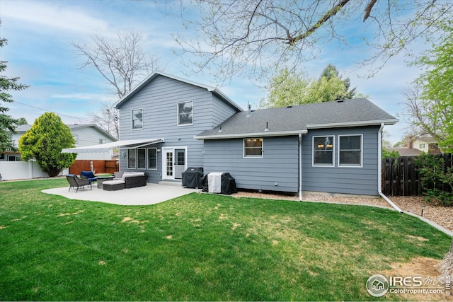 rear view of property featuring roof with shingles, a lawn, a patio area, a fenced backyard, and outdoor lounge area