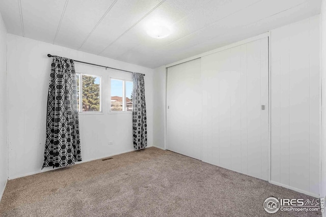 spare room featuring visible vents and carpet