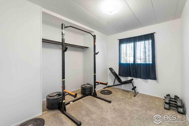 workout room featuring baseboards and carpet