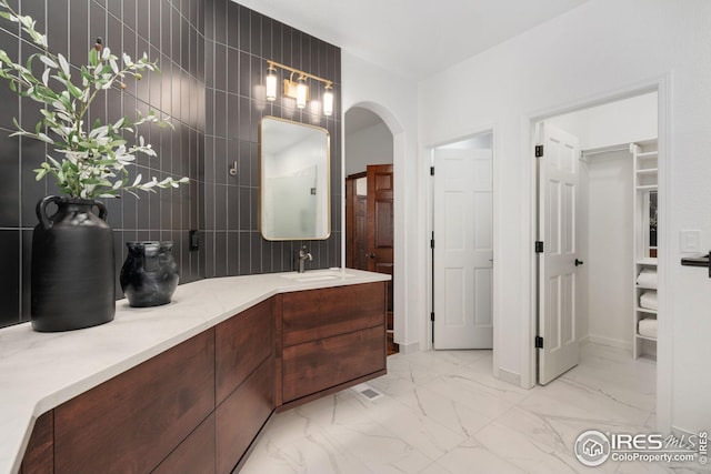 full bathroom with vanity, baseboards, and marble finish floor