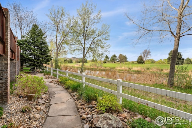 view of yard featuring fence and a rural view