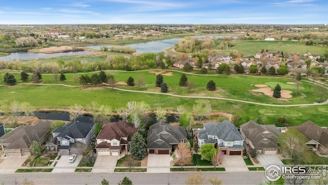 drone / aerial view with a water view, golf course view, and a residential view