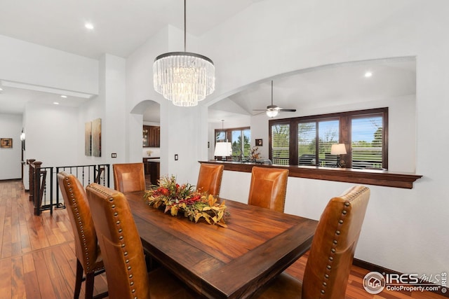 dining space with recessed lighting, arched walkways, light wood-style flooring, and ceiling fan with notable chandelier