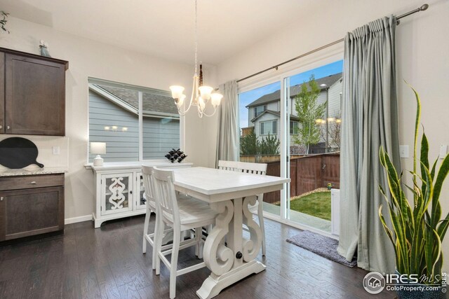 dining area featuring baseboards, dark wood-style flooring, and a notable chandelier