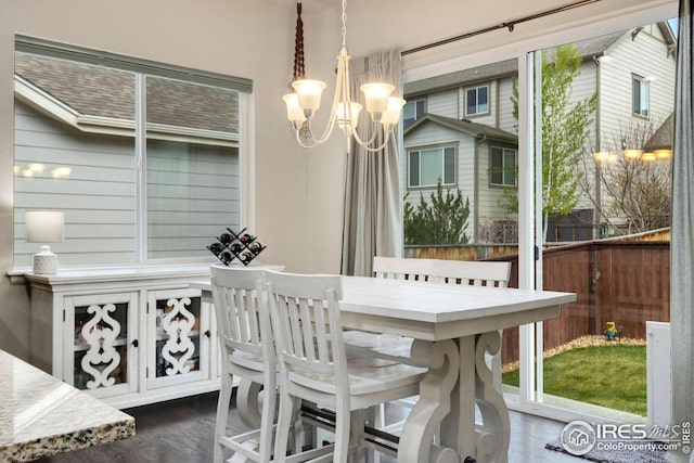 dining space featuring dark wood-style flooring and an inviting chandelier