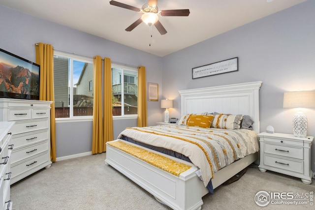 bedroom featuring light colored carpet, baseboards, and ceiling fan