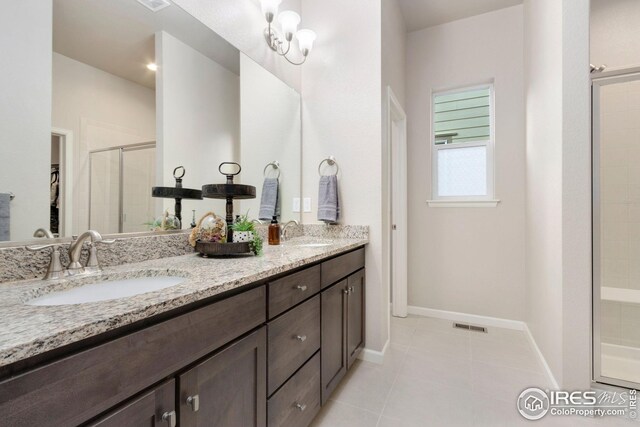 full bath with a sink, baseboards, tile patterned flooring, and a shower stall