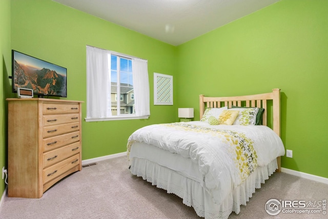 carpeted bedroom with baseboards and visible vents