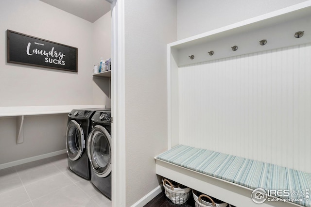 washroom featuring baseboards, tile patterned floors, washing machine and dryer, and laundry area