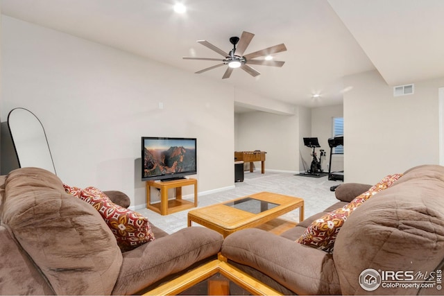 living room with visible vents, baseboards, ceiling fan, and light carpet