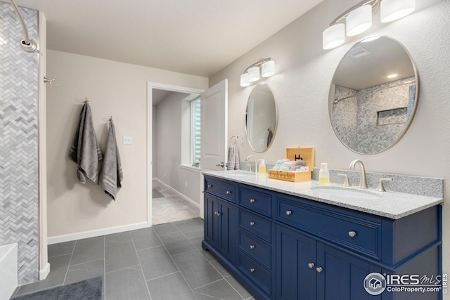 bathroom featuring a sink, tile patterned floors, a shower, and double vanity