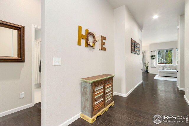 hall featuring baseboards and dark wood-style floors