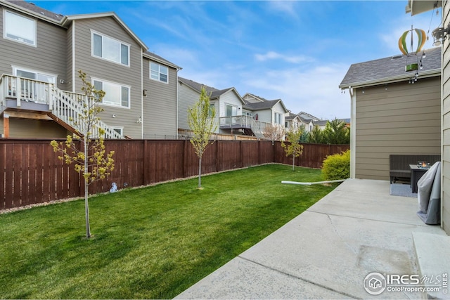 view of yard featuring a residential view, a fenced backyard, and a patio area
